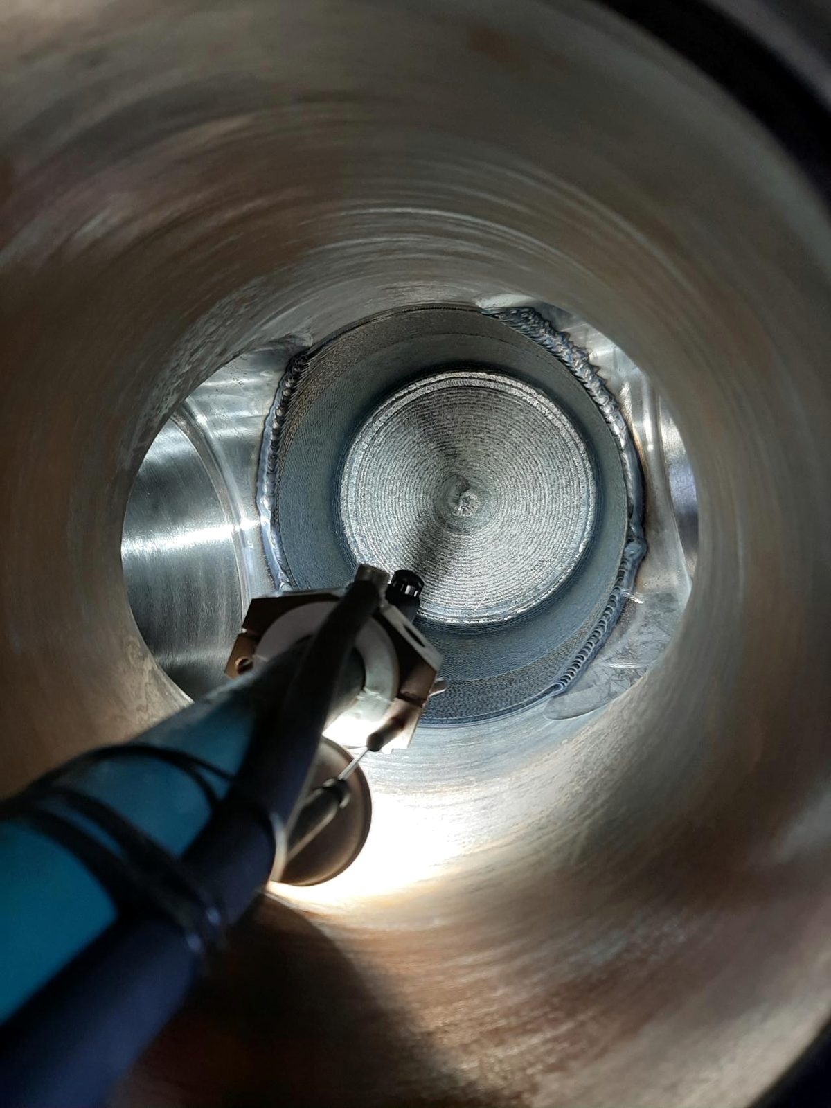 Torch inside a pipe bore during internal cladding