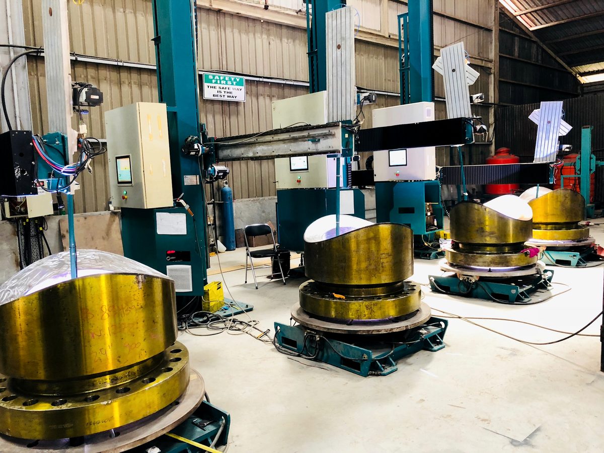 Vertical cladding cells with vessel components mounted on positioners